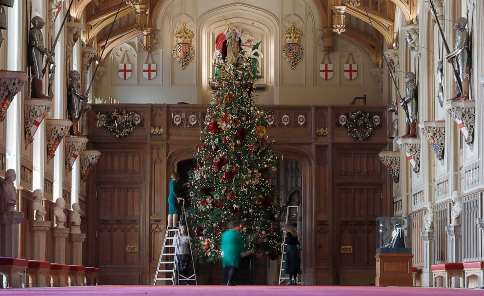 PHOTO: Staff adjust decorations on a Christmas tree in St George's Hall at Windsor castle during a media preview in Windsor, England, Nov. 29, 2019.