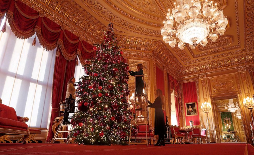 PHOTO: Staff adjust decorations on a Christmas tree in the Crimson Drawing room at Windsor castle during a media preview in Windsor, England, Nov. 29, 2019.
