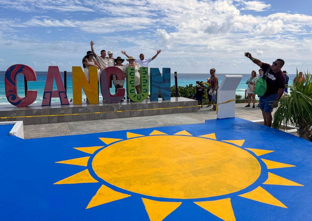 PHOTO: Tourists pose for a picture in front of a Cancun sign in Playa Delfines, at the Hotel Zone of Cancun, Mexico, Nov. 8, 2022.