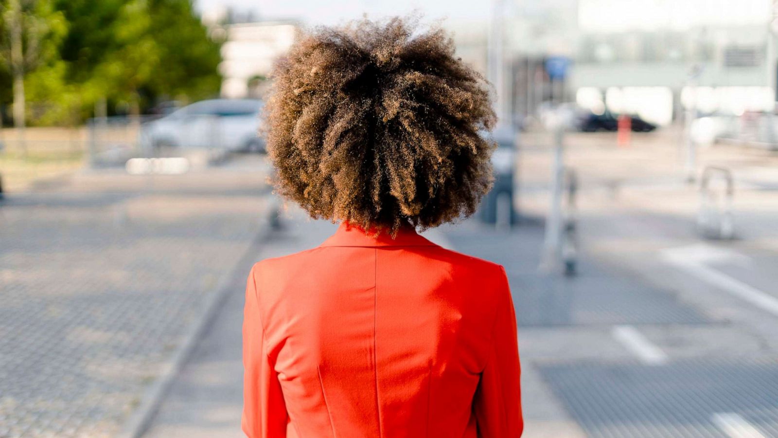 PHOTO: Back view of a young woman wearing fashionable red suit jacket.