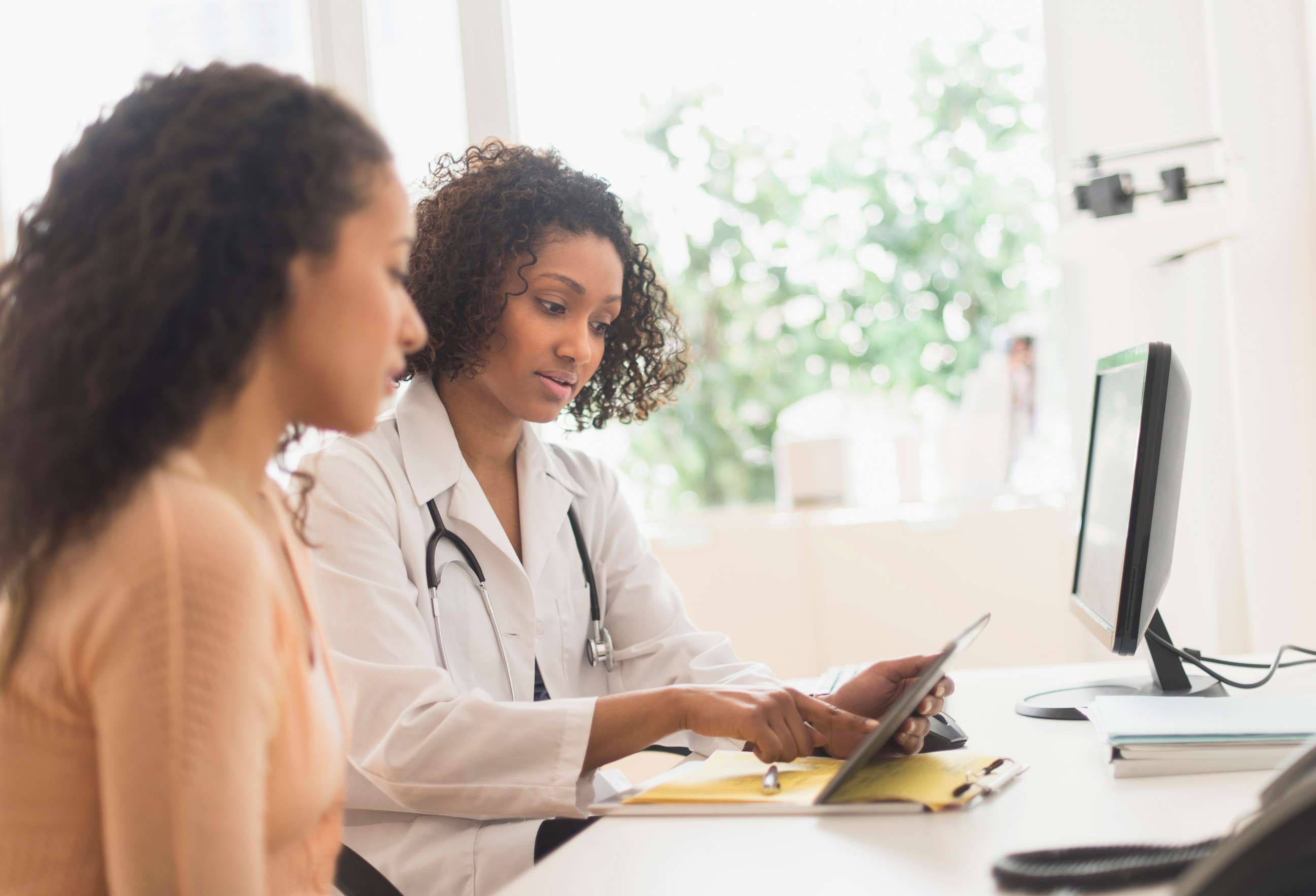 PHOTO: A woman looks over documents with her doctor in an undated stock photo. 