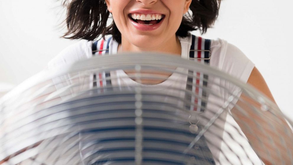 PHOTO: A woman sits in front of an electric fan in an undated stock photo.