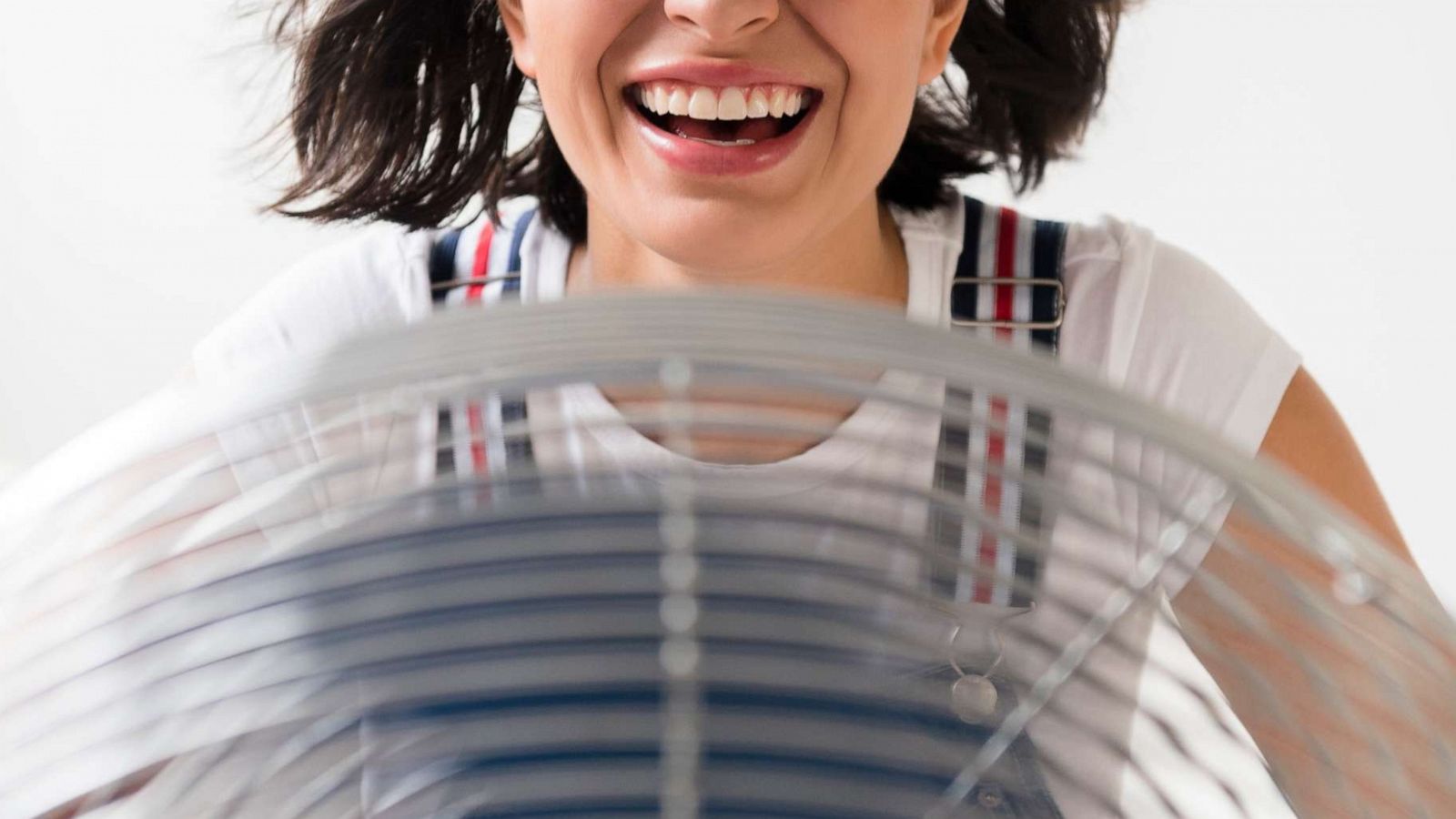 PHOTO: A woman sits in front of an electric fan in an undated stock photo.