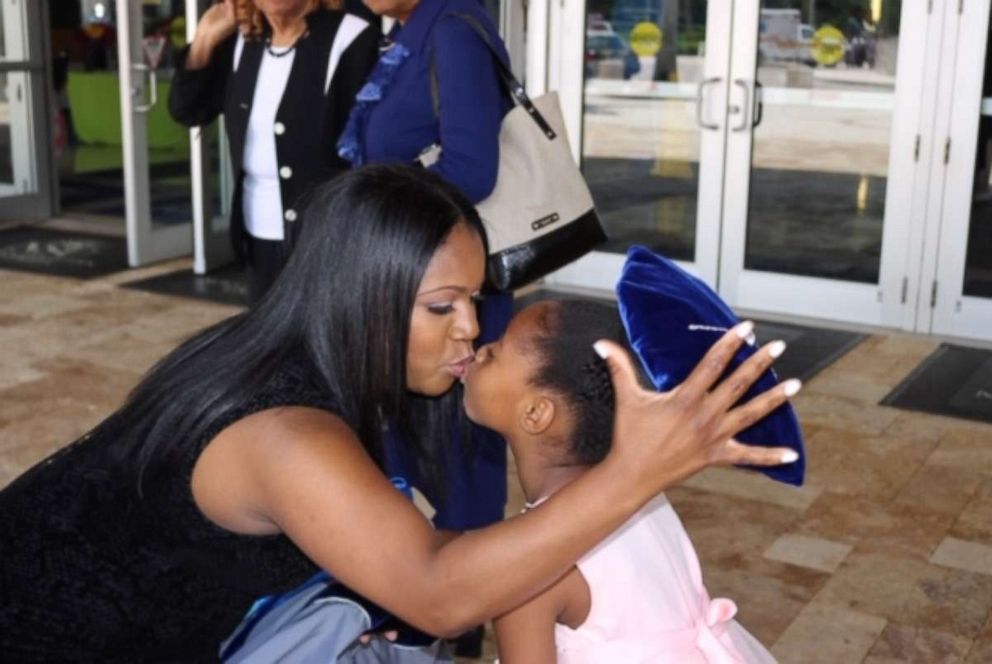 PHOTO: Yolanda Perkins kisses her daughter, Bella, 6, after Perkins' graduation ceremony on June 14.