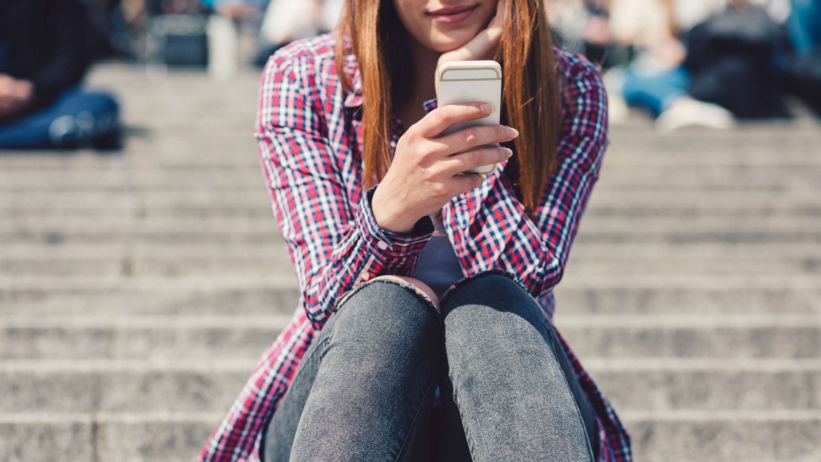 PHOTO: A young woman uses a smartphone in an undated stock photo.