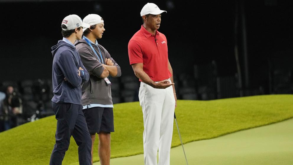 PHOTO: Tiger Woods, right, talks to his son Charlie and a friend while he warms up before a match between Los Angeles Golf Club and his Jupiter Links Golf Club, Jan. 14, 2025, in Palm Beach Gardens, Fla. 