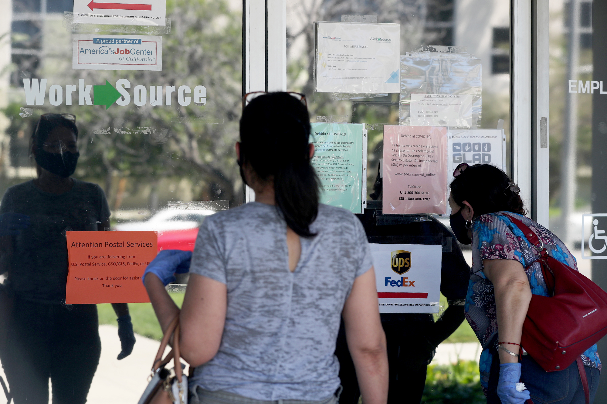 PHOTO: Estella Flores, right, and Maria Mora, left, look for information in front of the closed California State Employment Development Department on Thursday, May 14, 2020 in Canoga Park, CA.