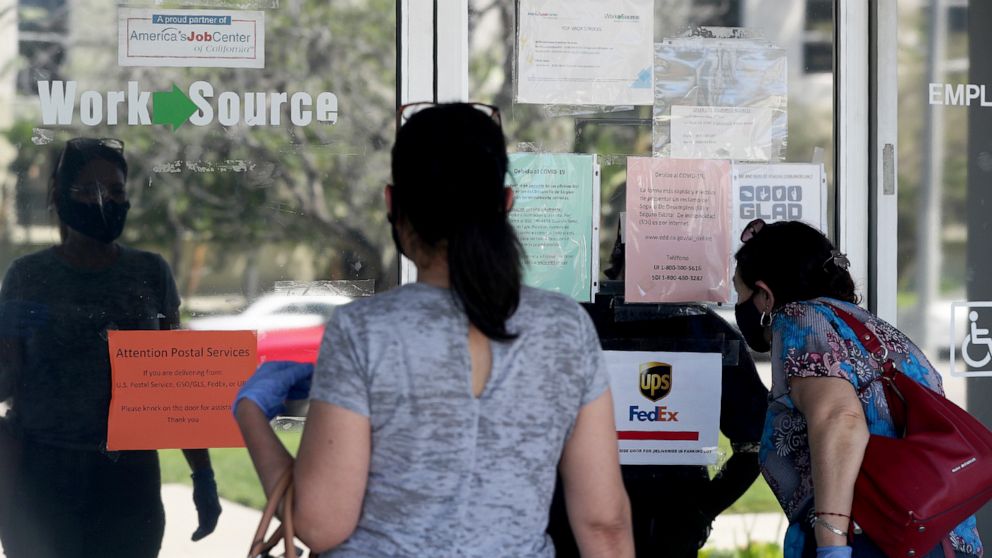 PHOTO: Estella Flores, right, and Maria Mora, left, look for information in front of the closed California State Employment Development Department on Thursday, May 14, 2020 in Canoga Park, CA.