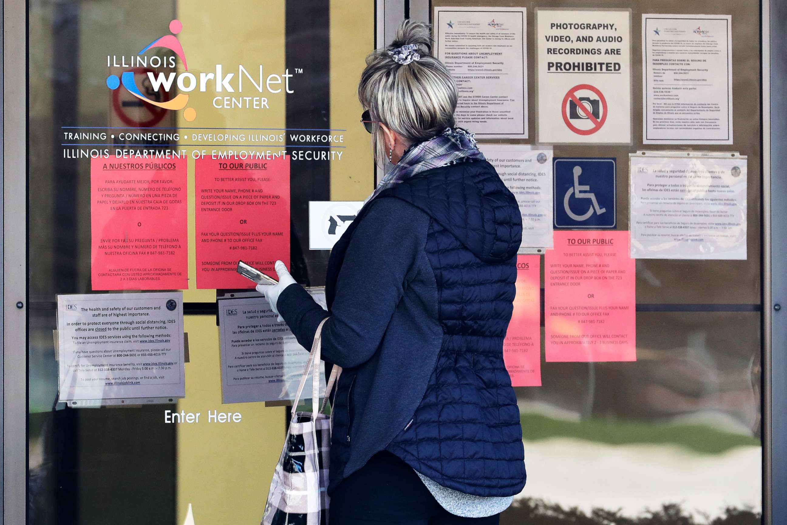 PHOTO: A woman checks job application information in front of Illinois Department of Employment Security)/WorkNet center in Arlington Heights, Ill., April 9, 2020.