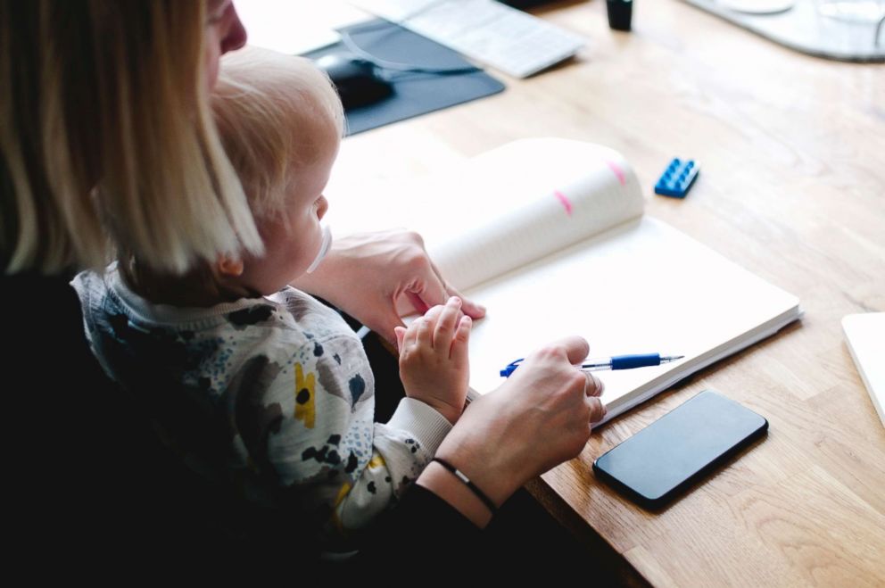 PHOTO: A working mom holds her child in this stock photo.