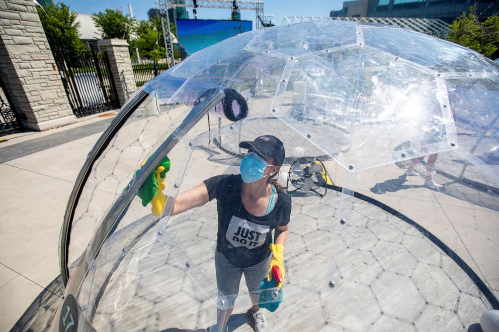 PHOTO: An employee cleans the dome before an outdoor yoga class by LMNTS Outdoor Studio in Toronto, June 21, 2020.