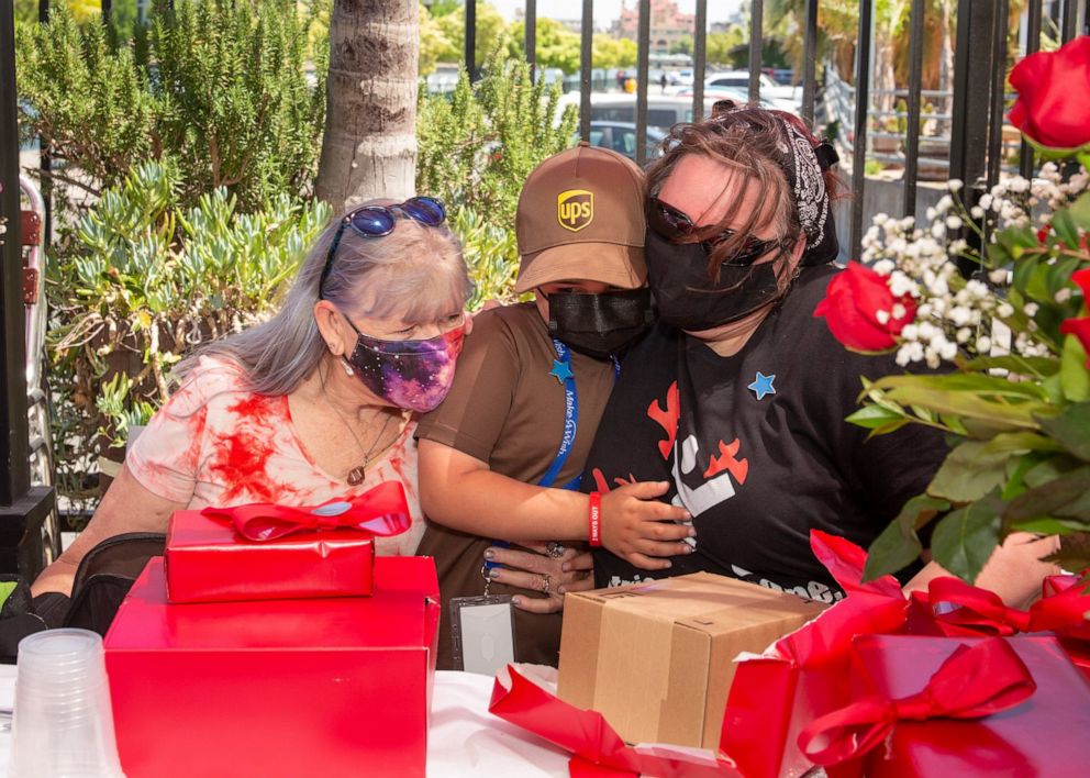 PHOTO: Mateo Toscano, 6, got to deliver packages as a honorary UPS worker for a day in Stockton, Calif., May 6, 2021.  Mateo hugs his grandmother Debbie Laughlin on the left and his mother, Cynthia Toscano, on the right.