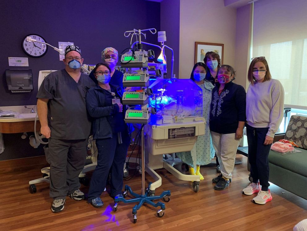 PHOTO: Kimberly Arias, wearing a hospital gown, poses with the healthcare providers at Baylor Scott and White who delivered her baby daughter Zaylynn.