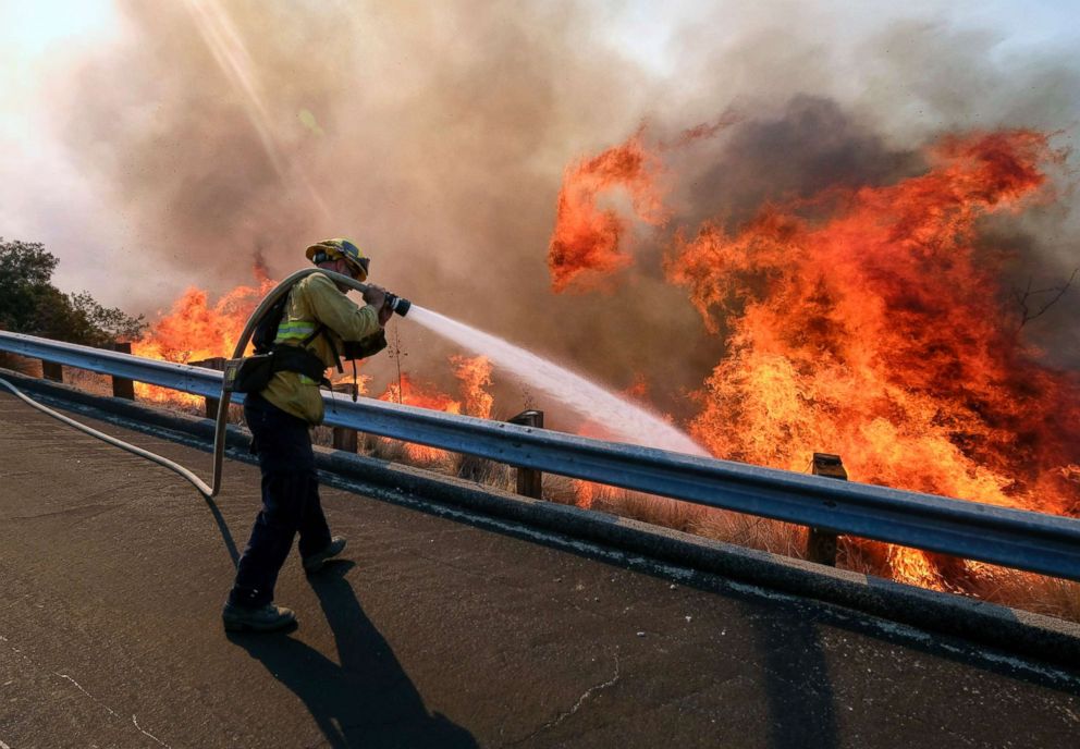 PHOTO: A firefighter battles a fire along the Ronald Reagan Freeway, aka state Highway 118, in Simi Valley, Calif., Nov. 12, 2018.