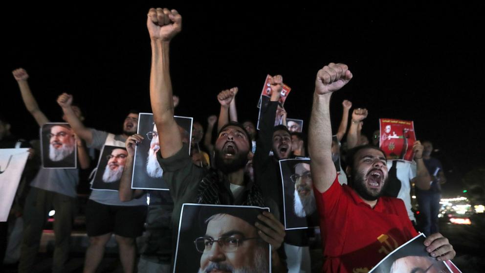 PHOTO: Lebanese and Palestinian men hold portraits of Hezbollah leader Sayyed Hassan Nasrallah, as they shout slogans during a protest in the southern port city of Sidon, Lebanon, Sept. 28, 2024. 