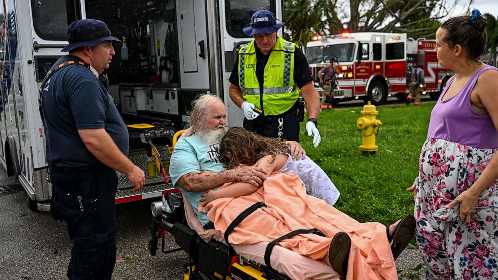 PHOTO: Alexa Haight hugs her grandfather Robin Haight before he is taken to the hospital by medics after getting injured by a reported tornado that hit his house in Fort Myers, Fla., Oct. 9, 2024.