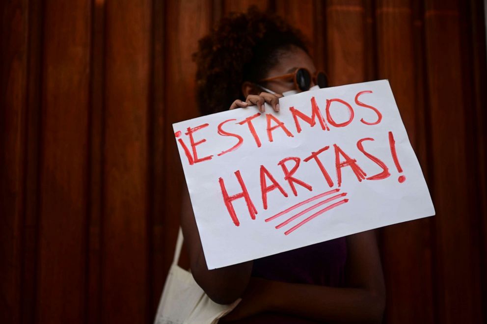 PHOTO: A member of a feminist collective holds a sign that reads in Spanish "We are fed up" during a demonstration against Sexual Violence, in San Juan, Puerto Rico, May 3, 2021.