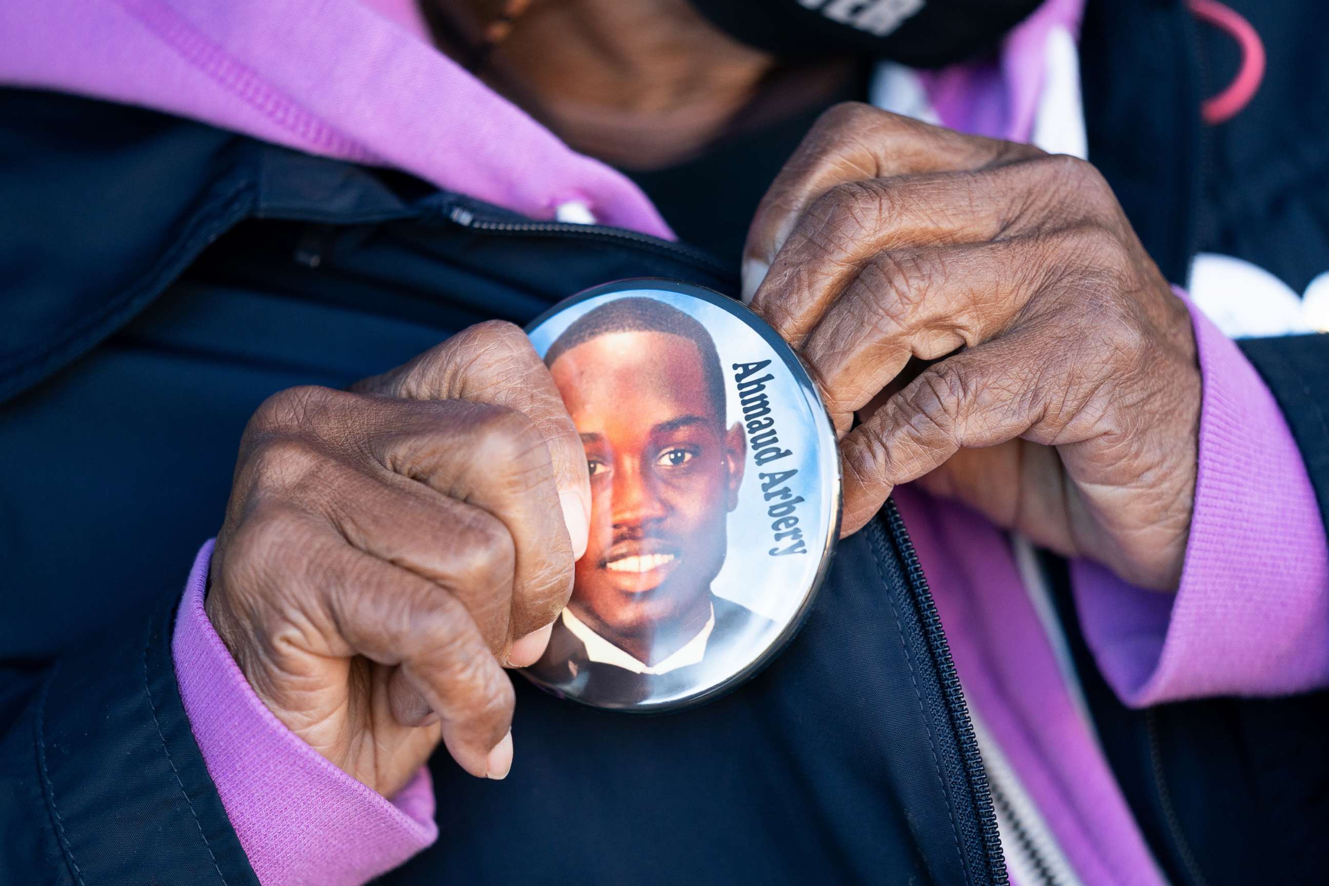 PHOTO: Annie Polite puts on a button for Ahmaud Arbery outside the Glynn County Courthouse as the jury deliberates in the trial of the killers of Ahmaud Arbery in Brunswick, Ga., Nov. 24, 2021.