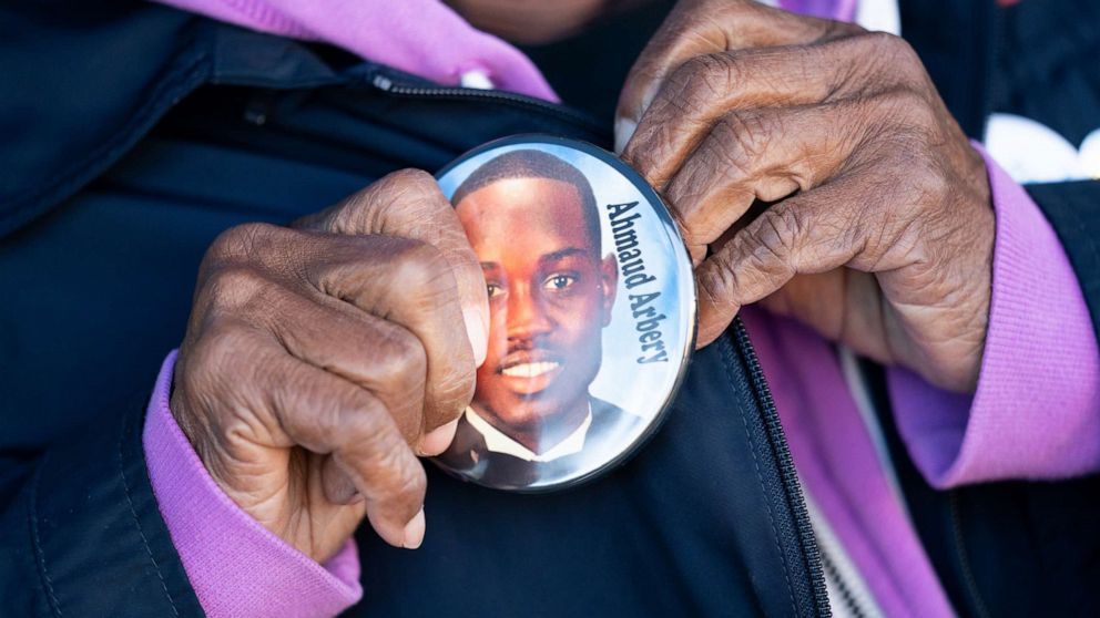 PHOTO: Annie Polite puts on a button for Ahmaud Arbery outside the Glynn County Courthouse as the jury deliberates in the trial of the killers of Ahmaud Arbery in Brunswick, Ga., Nov. 24, 2021.