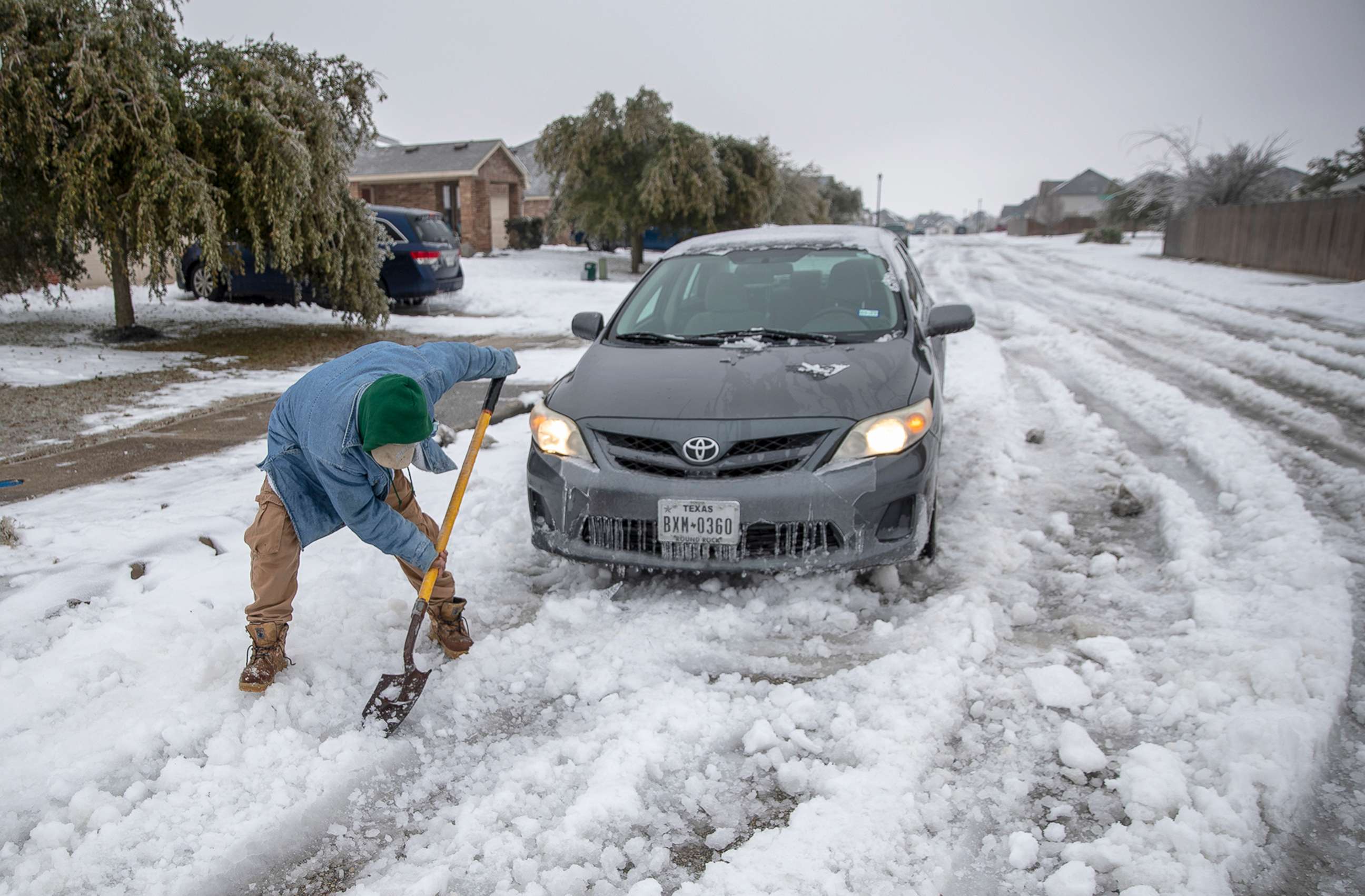 PHOTO: Jose Nives tries to shovel his way out after getting stuck in the middle of the street in Autin, Texas, Feb. 17, 2021.
