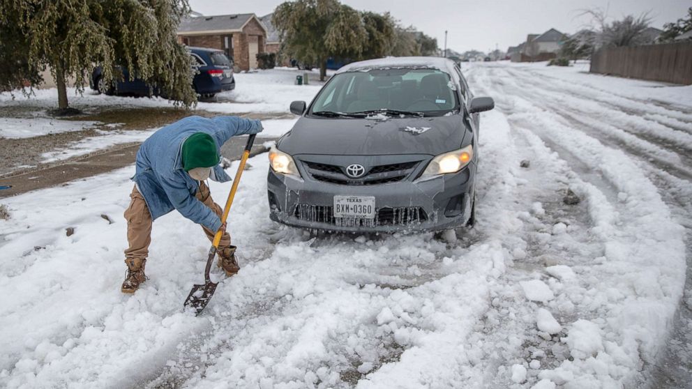 PHOTO: Jose Nives tries to shovel his way out after getting stuck in the middle of the street in Autin, Texas, Feb. 17, 2021.