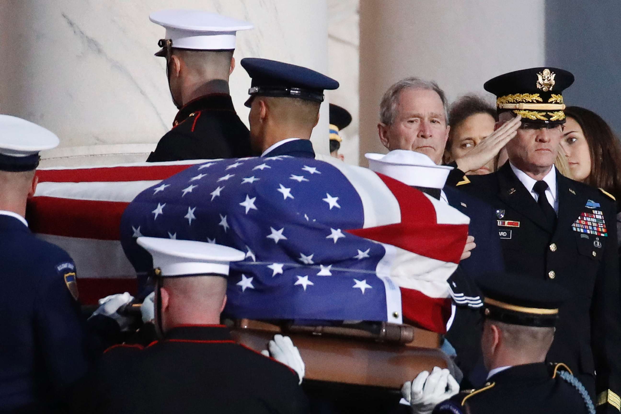PHOTO: Former President George W. Bush watches as the flag-draped casket of his father, former President George H.W. Bush is carried by a joint services military honor guard to lie in state in the rotunda of the U.S. Capitol, Dec. 3, 2018, in Washington.