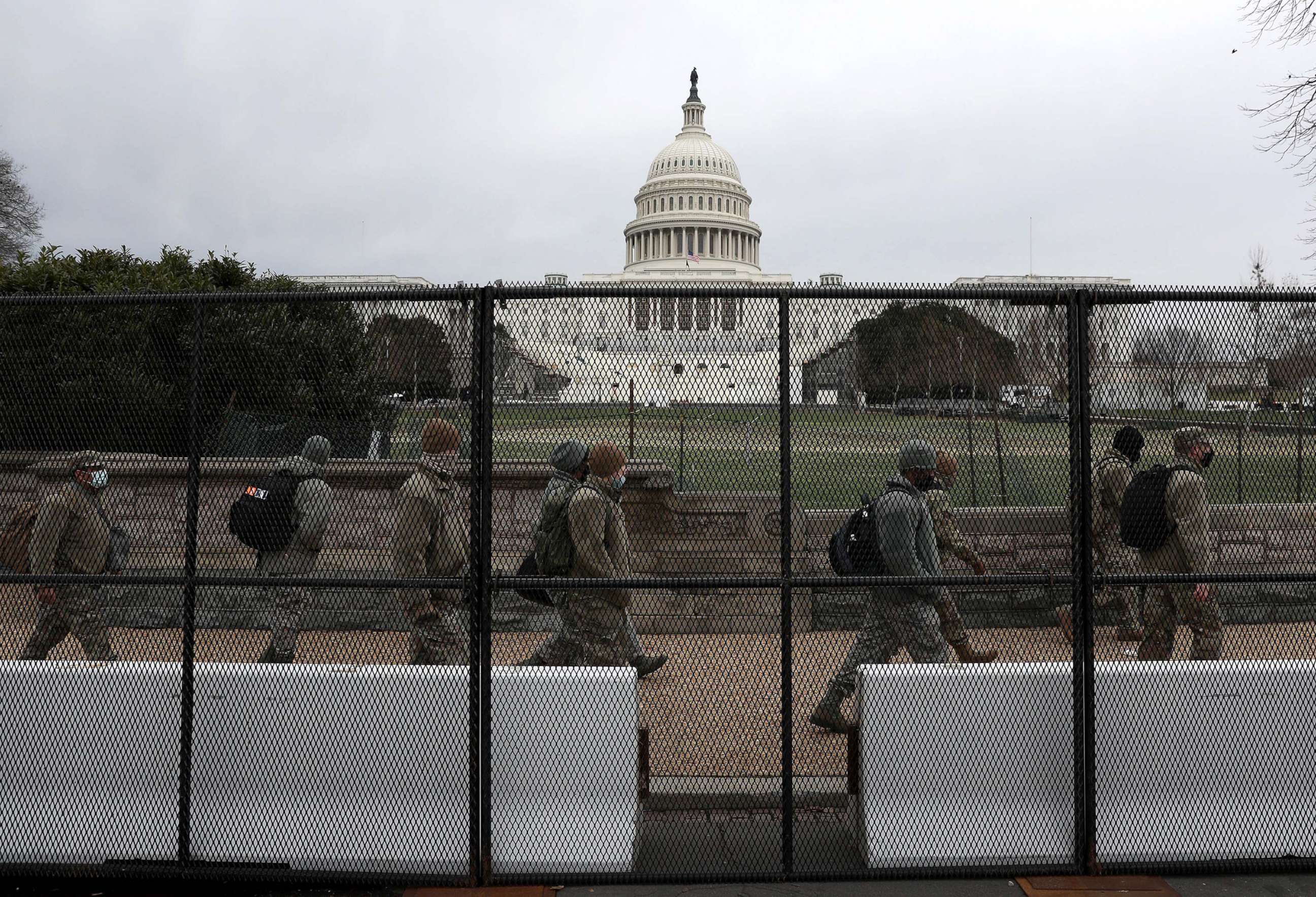 PHOTO: Members of the D.C. National Guard walk behind a fence placed around the U.S. Capitol building on Jan. 08, 2021.