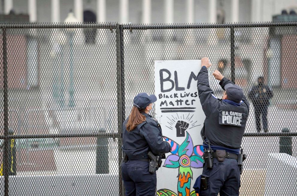 PHOTO: Capitol police remove a Black Lives Matter protest sign that was placed on the security fencing on the west side of the United States Capitol on on Jan. 8, 2021.