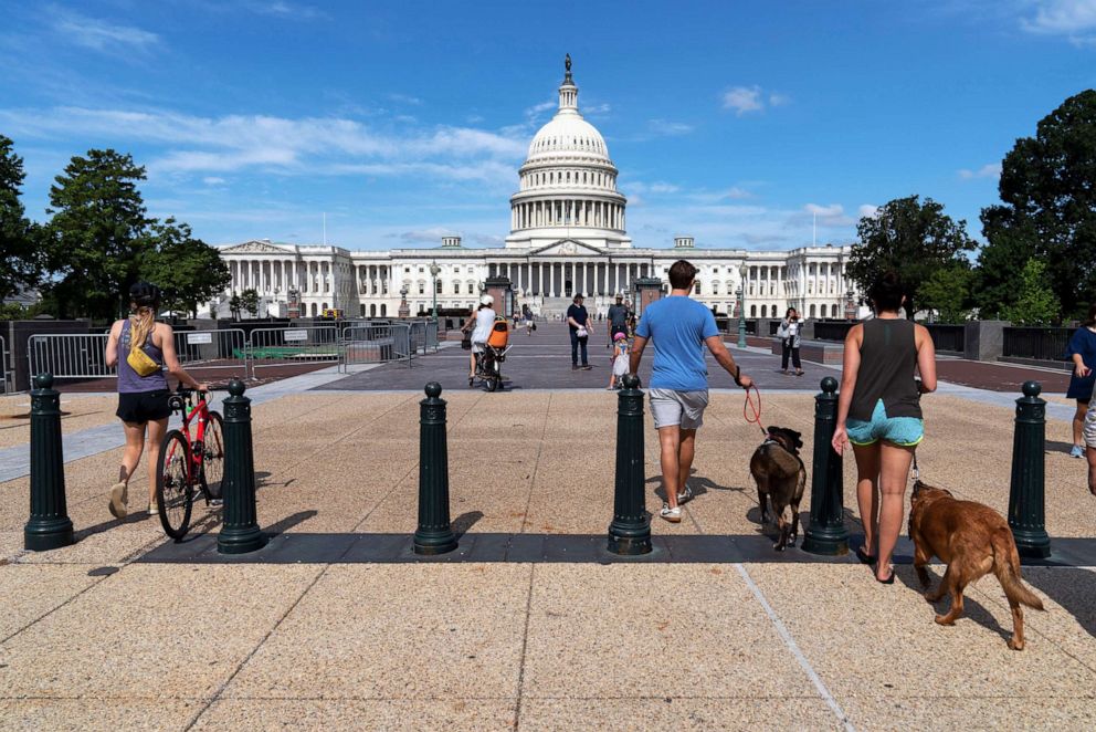 PHOTO: People walk to the U.S. Capitol after workers remove the fence surrounding the U.S. Capitol building, after six months of being erected following the Jan. 6 riot at the Capitol, July 10, 2021, in Washington. 