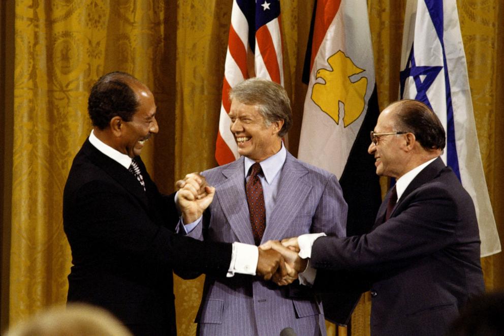 PHOTO: Egyptian President Anwar Sadat, U.S. President Jimmy Carter, and Israeli Prime Minister Menachem Begin join hands after the Camp David Accords September 18, 1978 in the East Room of the White House in Washington, DC. 