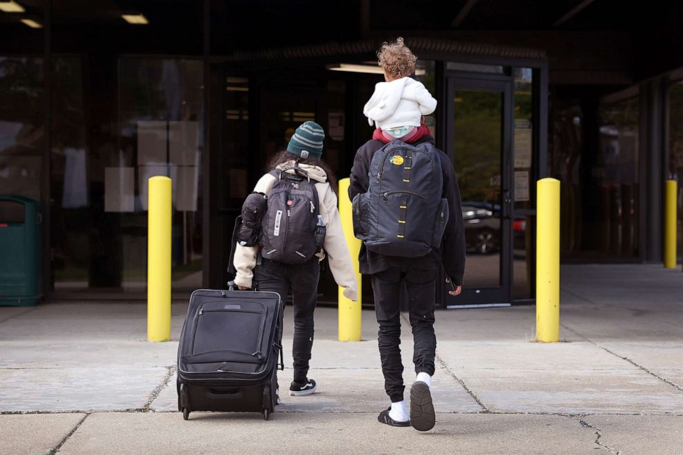 PHOTO: A migrant family from Venezuela arrives with their belongings at a police station where they will stay with other migrant families, May 9, 2023, in Chicago.