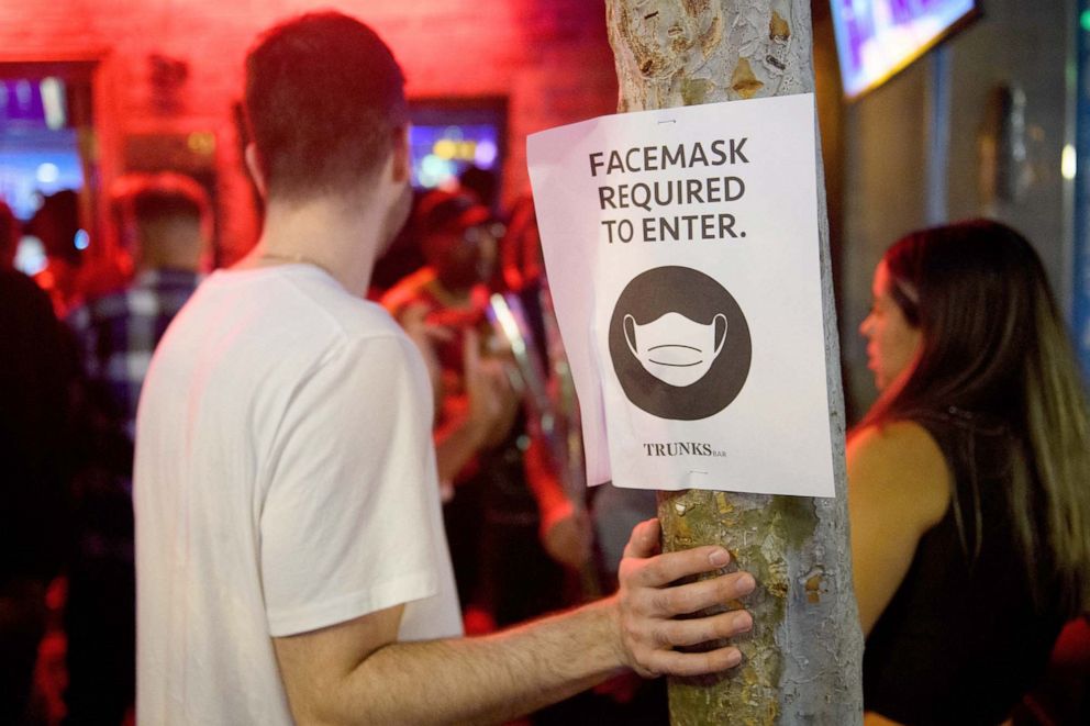 PHOTO: Face mask signage is displayed outside the Trunks bar after midnight early Sunday morning in West Hollywood, Calif., July 18, 2021.
