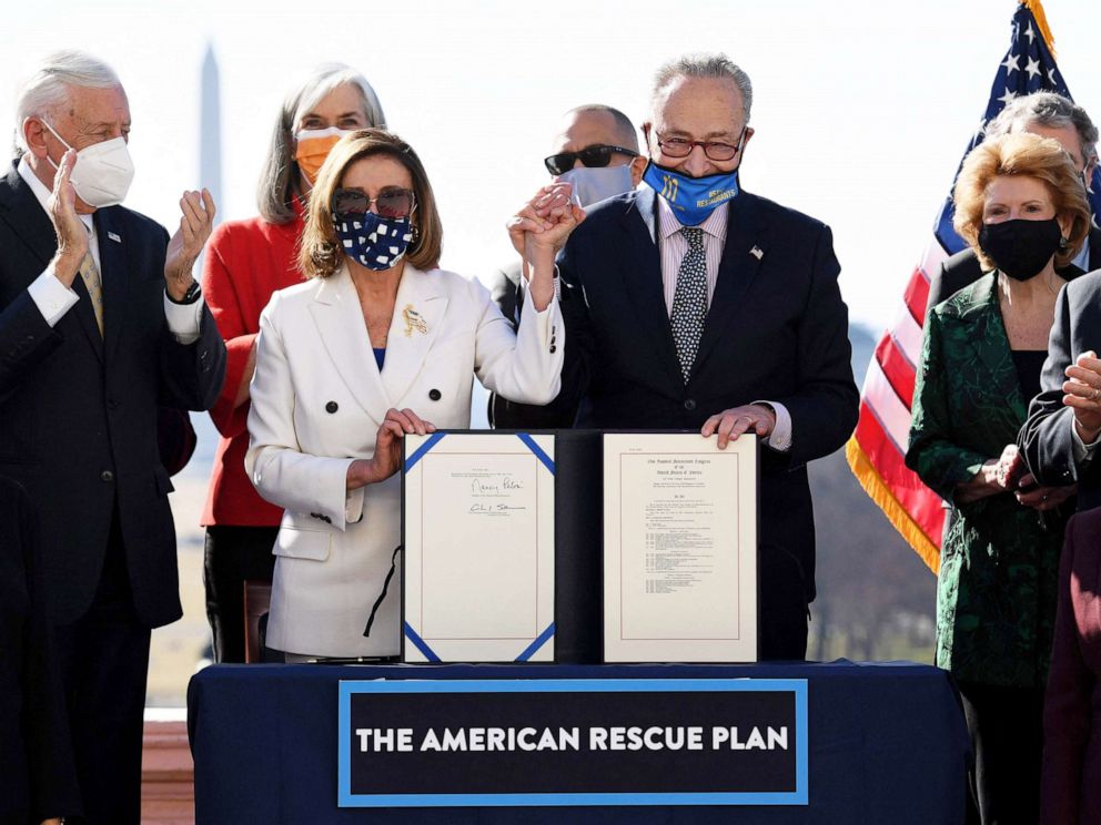 PHOTO: Speaker of the House Nancy Pelosi and Senate Majority Leader Chuck Schumer hold the signed American Rescue Plan Act at the Capitol on March 10, 2021.