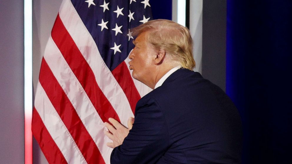 PHOTO: Former President Donald Trump embraces the American flag as he arrives on stage to address the Conservative Political Action Conference held in the Hyatt Regency on Feb. 28, 2021 in Orlando, Fla.