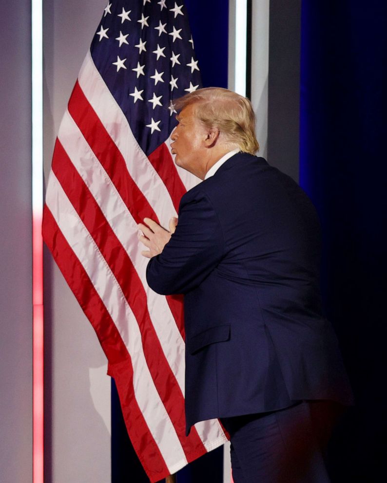 PHOTO: Former President Donald Trump embraces the American flag as he arrives on stage to address the Conservative Political Action Conference held in the Hyatt Regency on Feb. 28, 2021 in Orlando, Fla.