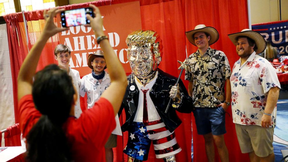 PHOTO: People take a picture with former President Donald Trump's statue on display at the Conservative Political Action Conference held in the Hyatt Regency on Feb. 27, 2021 in Orlando, Fla. 