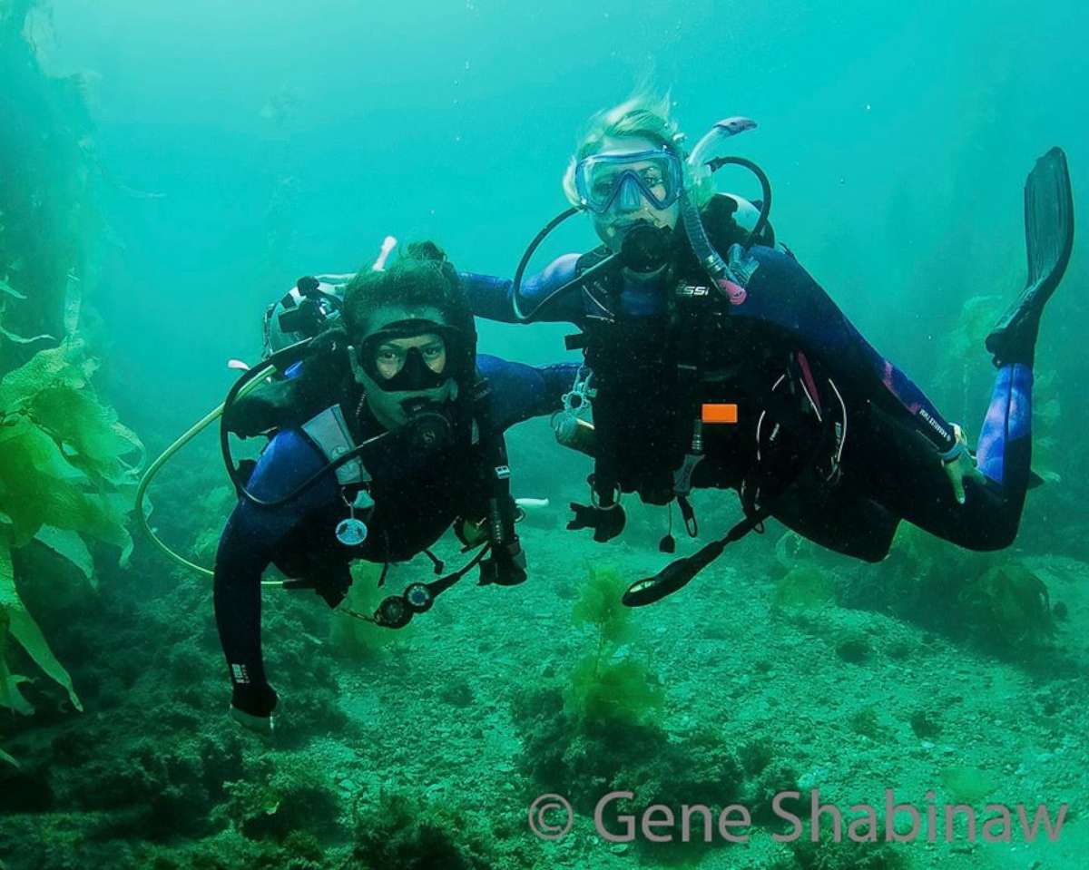 PHOTO: Two Dive Warriors pose for a photo in an underwater kelp forest.