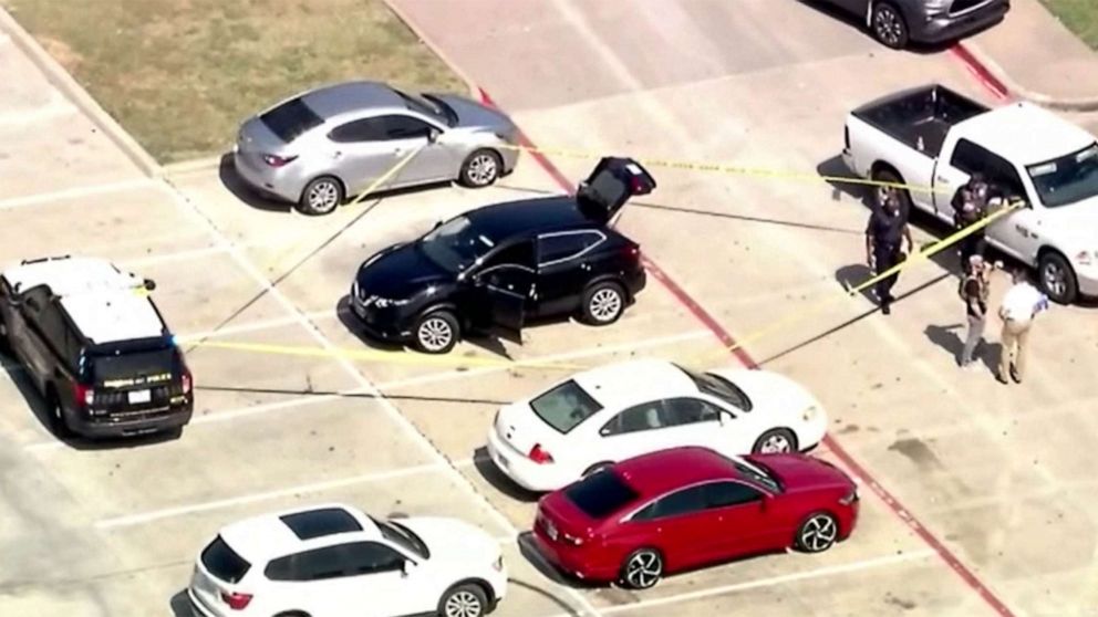 PHOTO: Une bande de scène de crime entoure un véhicule à l'extérieur du complexe sportif où un homme armé a été tué par la police après s'être présenté au camp d'été qui se tenait à Duncanville, Texas, le 13 juin 2022.