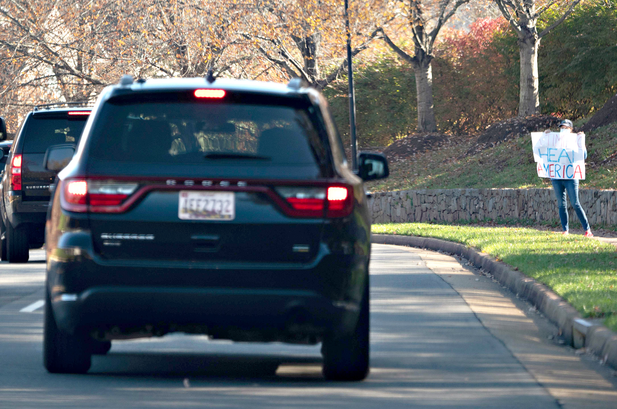 PHOTO:A woman holds up a sign that reads "A Time To Heal America" as the motorcade of President Donald Trump passes on the way to the Trump International Gold club in Sterling, Va. on Nov. 8, 2020.