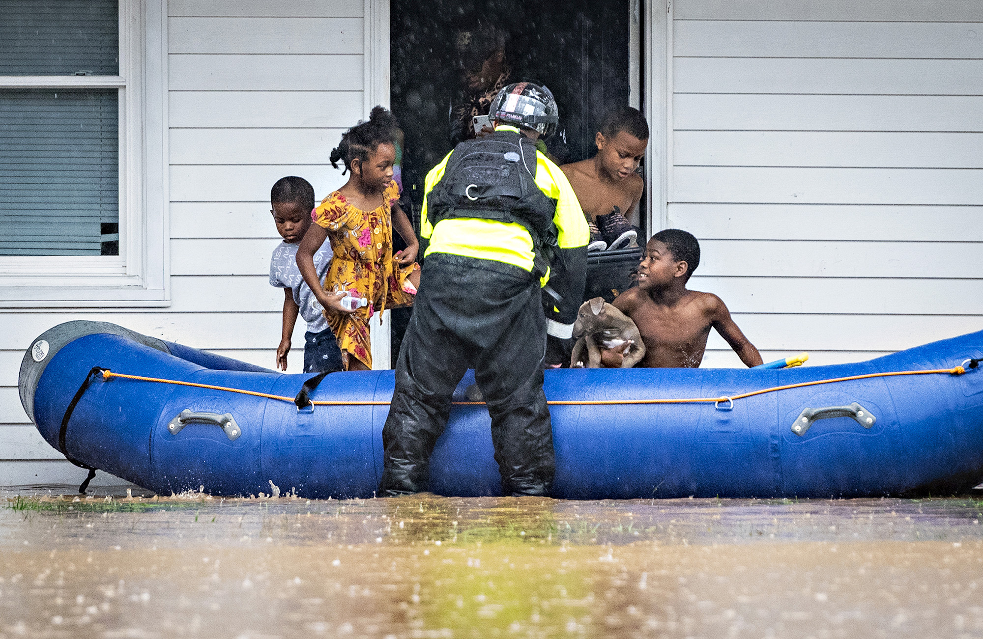 PHOTO: A firefighter helps young residents into a raft at Creekwood Apartments as firefighters evacuate the complex due to flooding in Winston-Salem, N.C., Nov. 12, 2020.