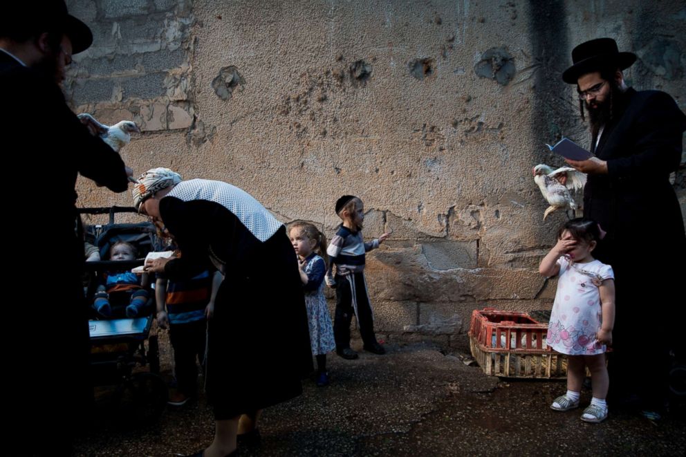 PHOTO: An ultra-Orthodox Jewish man swings a chicken over his children's head as part of the Kaparot ritual in Bnei Brak, Israel, Sept. 16, 2018.