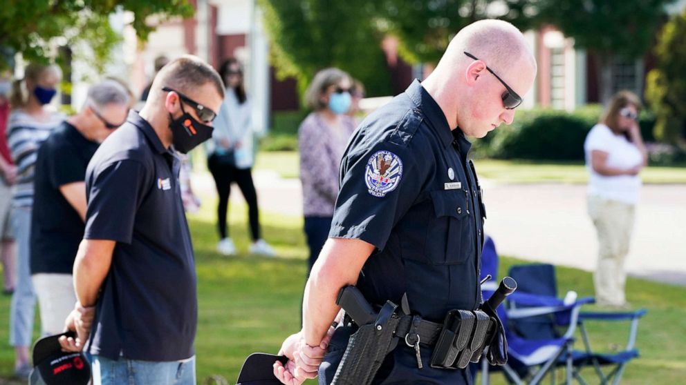 PHOTO: Officer Ben Hubbard, of the Collierville Police Department, and other residents pray during a vigil at Town Hall, Collierville, Tenn., Sept. 24, 2021.