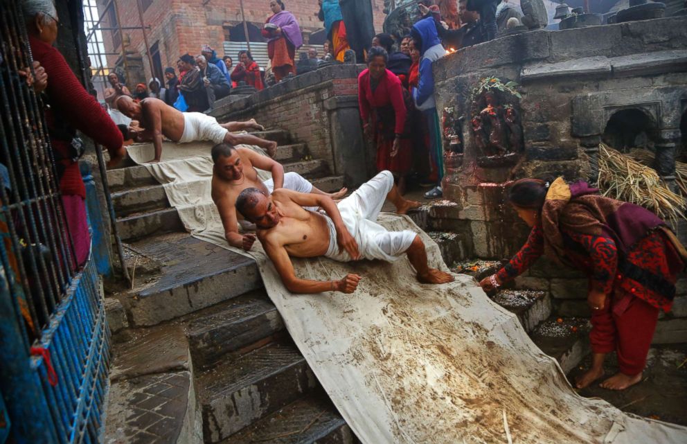 PHOTO: Nepalese Hindu devotees roll on the ground as part of a ritual during the Madhav Narayan festival in Bhaktapur, Nepal, Jan. 24, 2019.