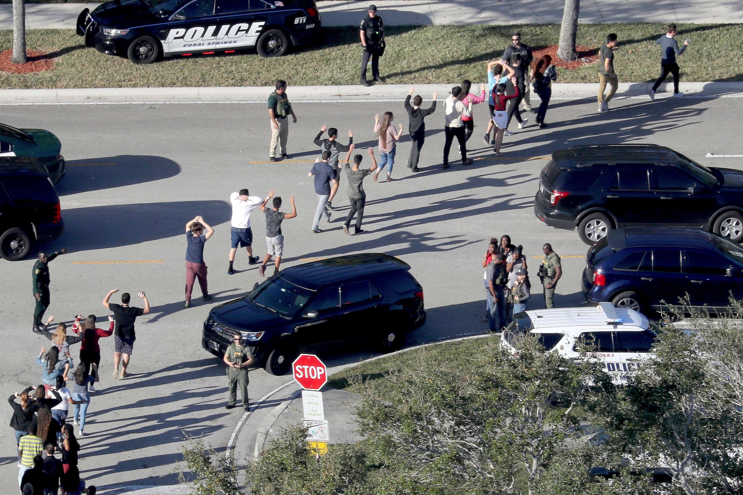 PHOTO: Students hold their hands in the air as they are evacuated by police from Marjory Stoneman Douglas High School in Parkland, Fla., after a shooter opened fire on the campus, Feb 14, 2018.