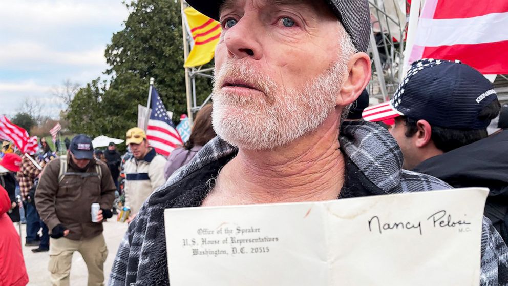 PHOTO: Richard "Bigo" Barnett, 60, from Gravette, Ark., shows off the envelope he took from House Speaker Nancy Pelosi's office at the Capitol in Washington, Jan. 6, 2021. 