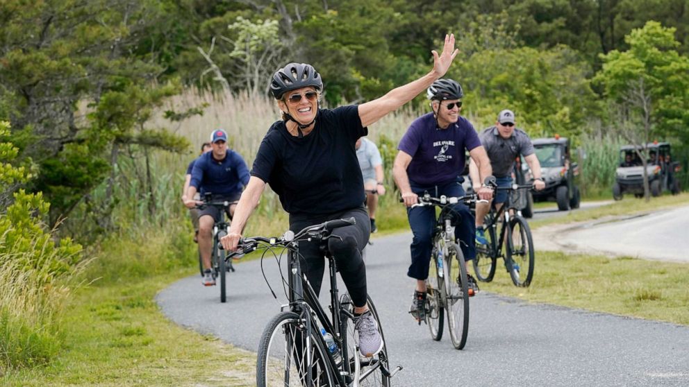 PHOTO: First lady Jill Biden waves as she rides her bike with President Joe Biden in Rehoboth Beach, Del., June 3, 2021.