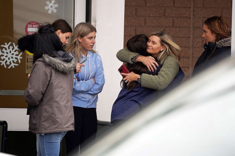 PHOTO: A parent hugs a child as other come to pick up students from the Meijer store in Oxford following an active shooter situation at Oxford High School in Oxford, Mich., Nov. 30, 2021.  