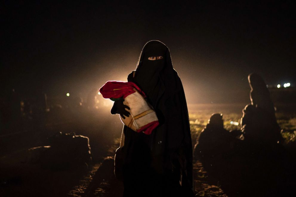 PHOTO: A woman who was evacuated out of the last territory held by Islamic State militants holds her baby after being screened by U.S.-backed Syrian Democratic Forces (SDF) in the desert outside Baghouz, Syria, Feb. 25, 2019. 