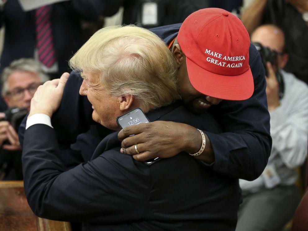 PHOTO: President Donald Trump takes rapper Kanye West in his arms during a meeting in the White House oval office on October 11, 2018.