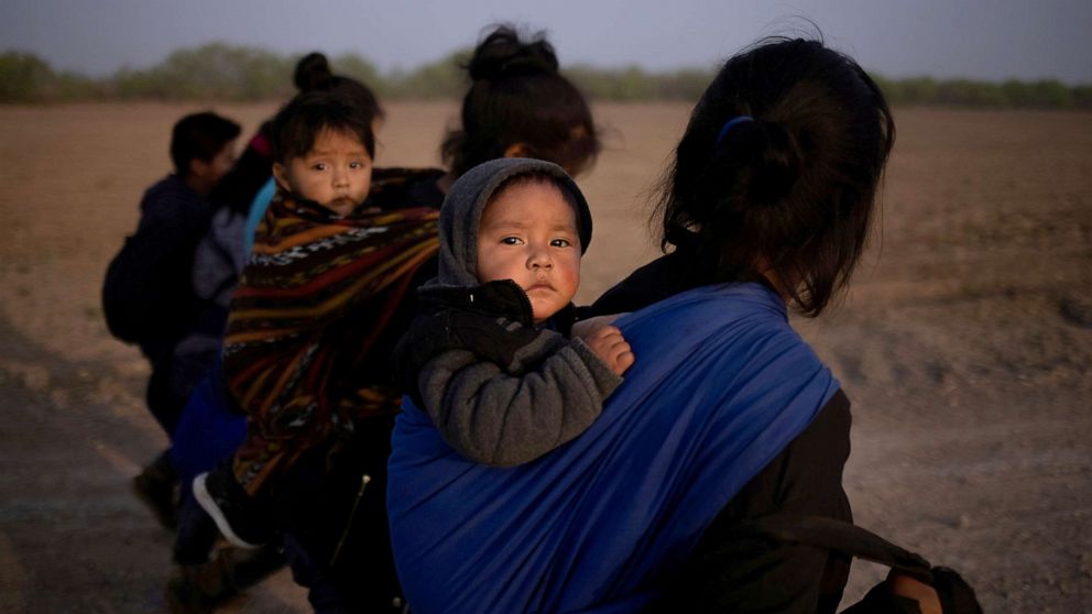 PHOTO: Marvin and Brando, both one-year-old asylum-seeker boys from Guatemala, look out from their baby carriers after they crossed with their mothers the Rio Grande river into the United States from Mexico on a raft, in Penitas, Texas, March 17, 2021.